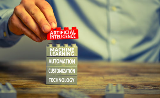 Man in business shirt playing with toy blocks. There are artificial intelligence related words printed on the blocks